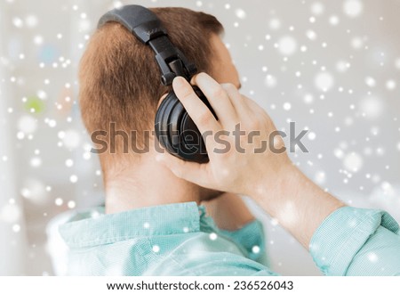 technology, music, leisure and people concept - close up of man in headphones at home from back