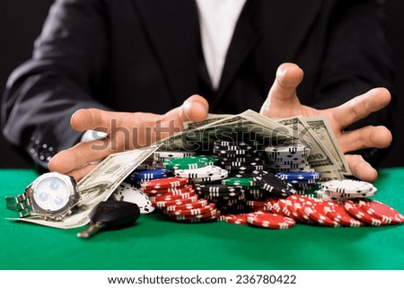 casino, gambling, people and entertainment concept - close up of poker player with chips, money and personal stuff at green casino table