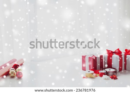 holidays and celebration concept - close up of christmas presents, decoration paper, ribbons and scissors