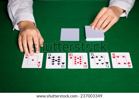 casino, gambling, poker, people and entertainment concept - close up of holdem dealer hands with playing cards