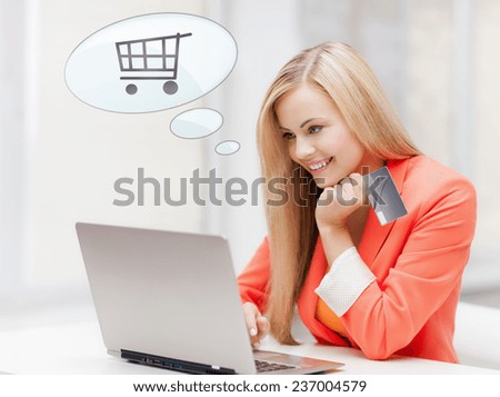 online shopping, people and technology concept - smiling young woman with laptop computer, credit card and text bubble with trolley