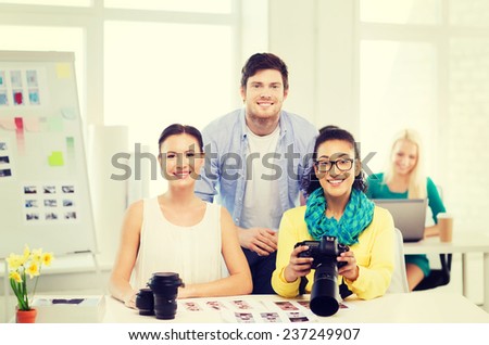 business, education, photography, office and startup concept - smiling creative team with photocamera working in office