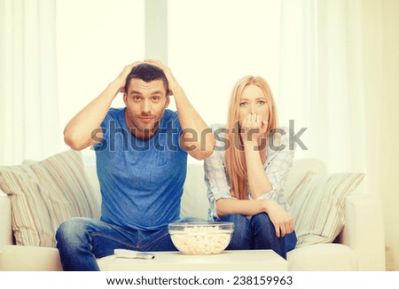 food, love, family, sports, entretainment and happiness concept - upset couple after sports team loss