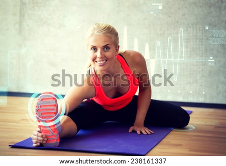 fitness, sport, training, future technology and lifestyle concept - smiling woman doing exercises on mat in gym over cardiogram projection