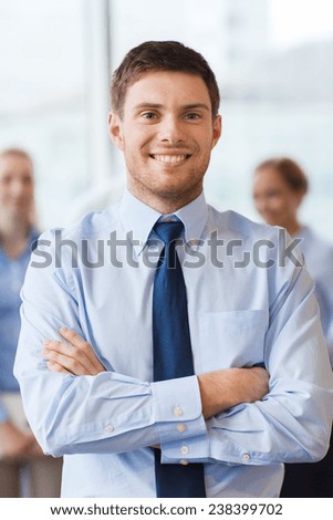 business, people and teamwork concept - smiling businessman with group of businesspeople in office