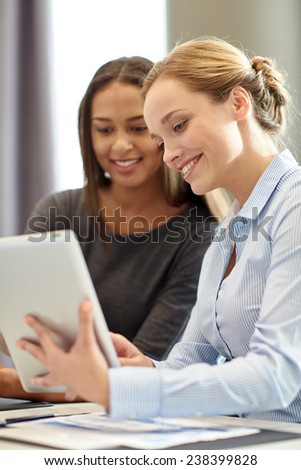business, people and technology concept - smiling businesswomen with tablet pc computer meeting in office