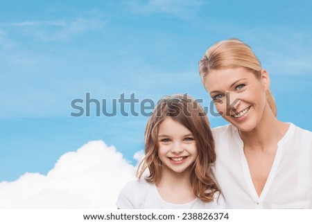 family, childhood, happiness and people - smiling mother and little girl over blue sky and white cloud background