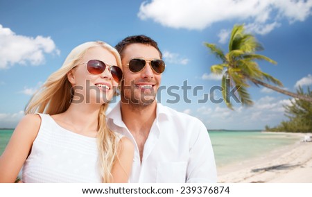 summer holidays, travel, tourism, people and dating concept - happy couple in shades over tropical beach background