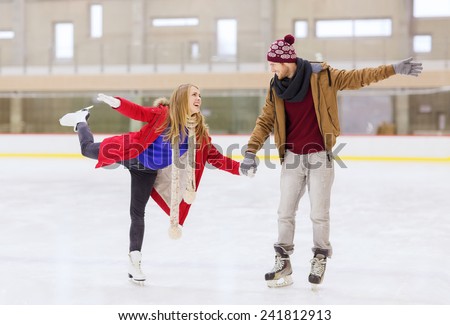people, friendship, sport and leisure concept - happy couple holding hands on skating rink