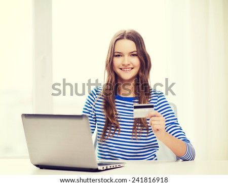 home, technology, banking, money and internet concept - smiling teenage girl with laptop computer and cradit card at home