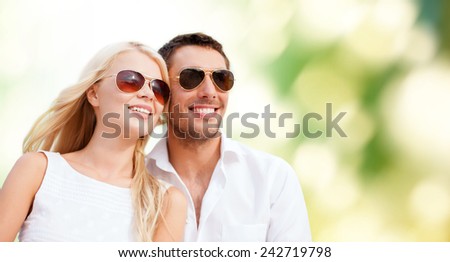 summer holidays, people, ecology and dating concept - happy couple in shades over green background