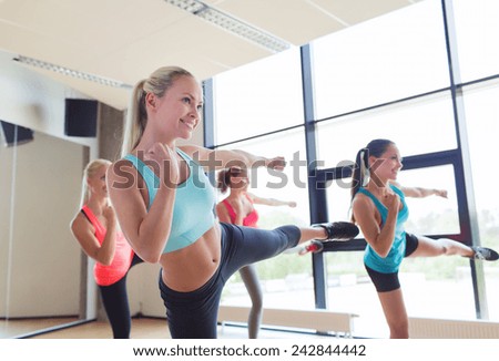 fitness, sport, people, martial arts and gym concept - group of women working out and standing in battle stance