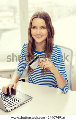 home, technology, banking, money and internet concept - smiling teenage girl with laptop computer and credit card at home