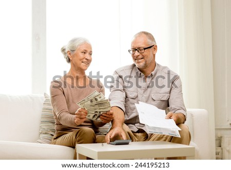 family, business, savings, age and people concept - smiling senior couple with papers, money and calculator at home