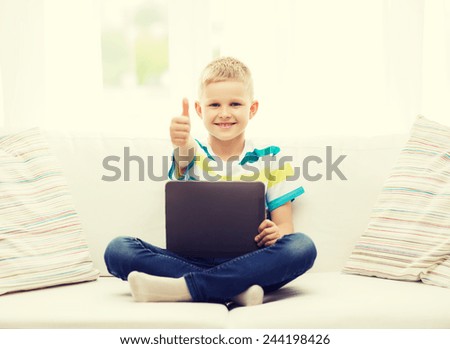 home, leisure and new technology concept - smiling little boy with tablet pc computer at home showing thumbs up