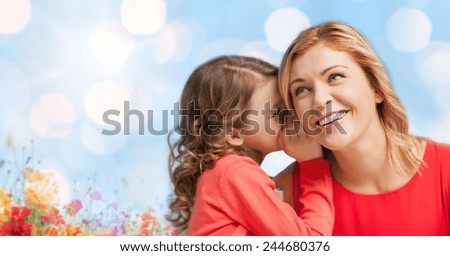 people, trust, love, family and motherhood concept - happy daughter whispering gossip to her mother over blue lights and poppy field background