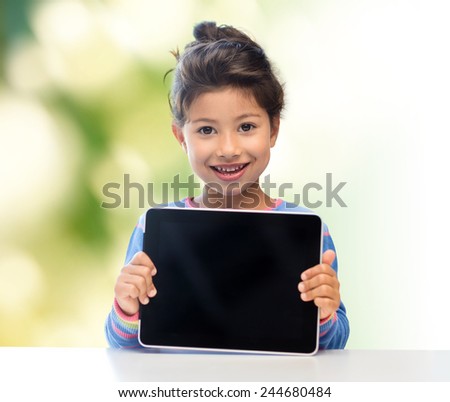 education, children, technology, advertisement and people concept - happy little girl with tablet pc computer over green background