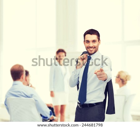 business and office concept - handsome buisnessman with jacket over shoulder pointing finger at you