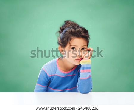 education, people, childhood and emotions concept - sad or bored little school girl over green chalk board background