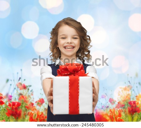 people, childhood, summer and holidays concept - happy smiling girl with gift box over poppy field background