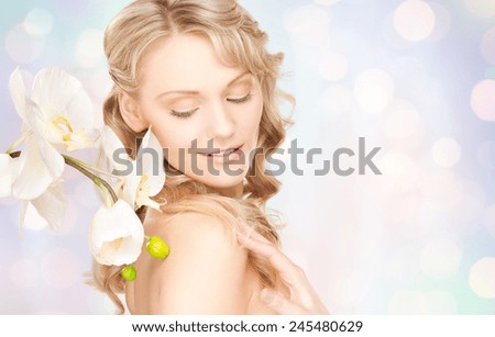 beauty and people concept - face of beautiful young woman over blue lights background