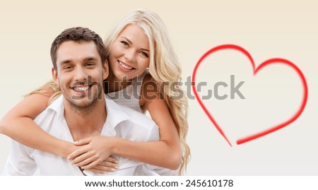holiday, valentine's day, dating and love concept - happy couple having fun over beige background and red heart shape