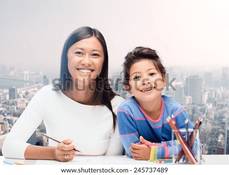 family, children and people concept - happy mother and daughter drawing over city background
