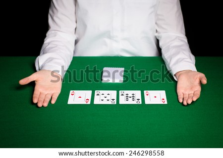 casino, gambling, poker, people and entertainment concept - close up of holdem dealer with playing cards