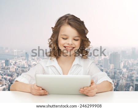 people, technology and children concept - happy smiling girl with tablet pc computer over city background
