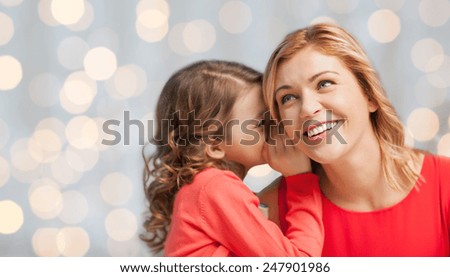people, trust, love, family and motherhood concept - happy daughter whispering gossip to her mother over holiday lights background