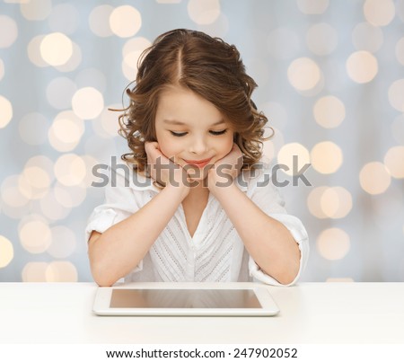 people, technology, education and children concept - happy smiling girl with tablet pc computer over holidays lights background