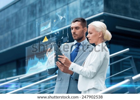 business, partnership, technology and people concept - businessman and businesswoman working with tablet pc computer charts on virtual screens on city street