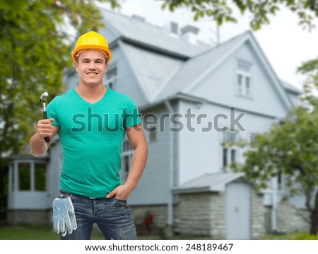 repair, construction, people, building and maintenance concept - smiling male manual worker in protective helmet holding hammer over house background