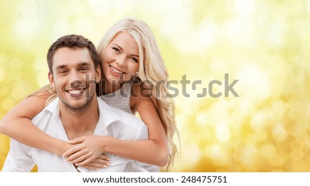 summer holiday, vacation, dating and love concept - happy couple having fun over yellow lights background