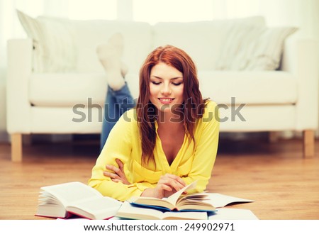 education and home concept - smiling student girl reading books at home