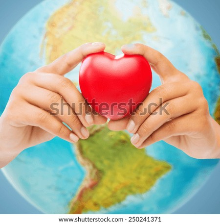 people, love, health, environment and charity concept - close up of woman hands holding red heart over earth globe and blue background