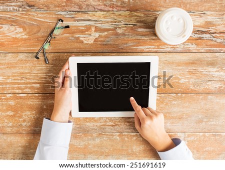 business, education, people and technology concept - close up of female hands pointing finger to tablet pc computer black blank screen with coffee cup and eyeglasses