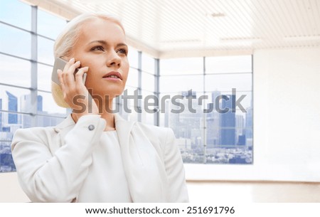business, technology and people concept - businesswoman calling on smartphone over office room or new apartment background