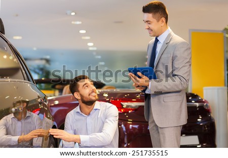 auto business, car sale, technology and people concept - happy man and car dealer with tablet pc computer talking in auto show or salon