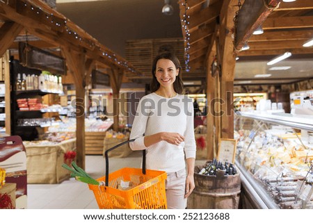 sale, shopping, consumerism and people concept - happy young woman with food basket in market