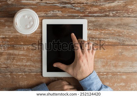 business, education, people and technology concept - close up of male hands with tablet pc computer and coffee paper cup on table