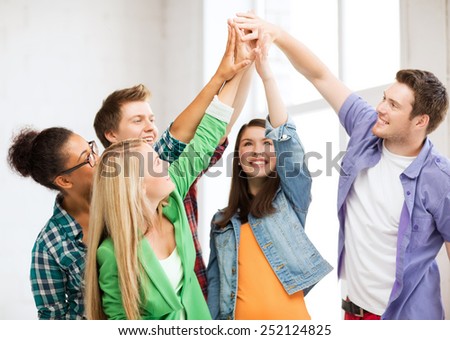 education and friendship concept - happy students giving high five at school