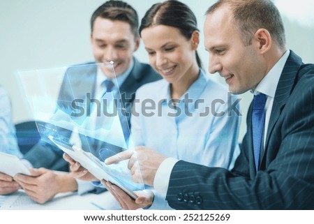 business, technology, development and people concept - smiling business team with tablet pc computer and virtual screen projection having discussion in office