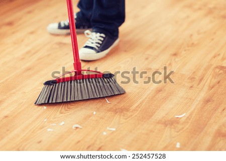 cleaning and home concept - close up of male brooming wooden floor