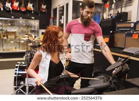 music, sale, people, musical instruments and entertainment concept - happy man and woman with drum kit at music store