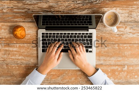 business, education, people and technology concept - close up of female hands with laptop computer, muffin and coffee cup on table