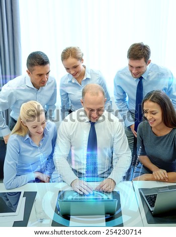 business, people, technology and teamwork concept - smiling business team with laptop computer and virtual projection working in office