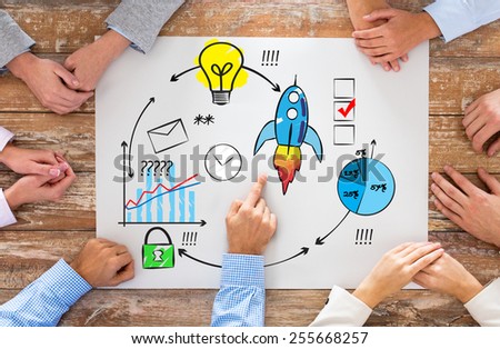 business, people, strategy and team work concept - close up of hands pointing finger to paper with scheme on table in office