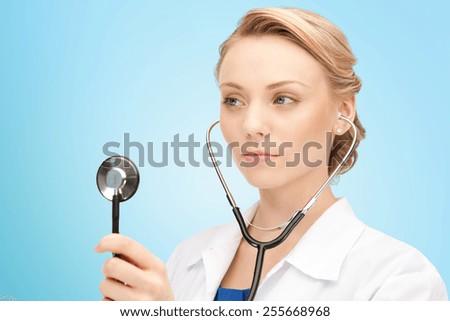 people, medicine, equipment and profession concept - young female doctor with stethoscope over blue background