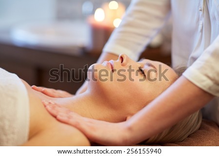 people, beauty, spa, healthy lifestyle and relaxation concept - close up of beautiful young woman lying with closed eyes and having massage in spa